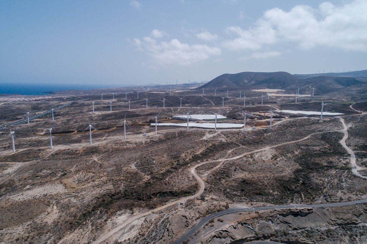 Vista aérea de um extenso parque eólico em uma paisagem seca e árida.