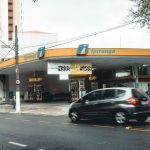 Posto Ipiranga movimentado, com veículos passando e abastecendo em uma área urbana.