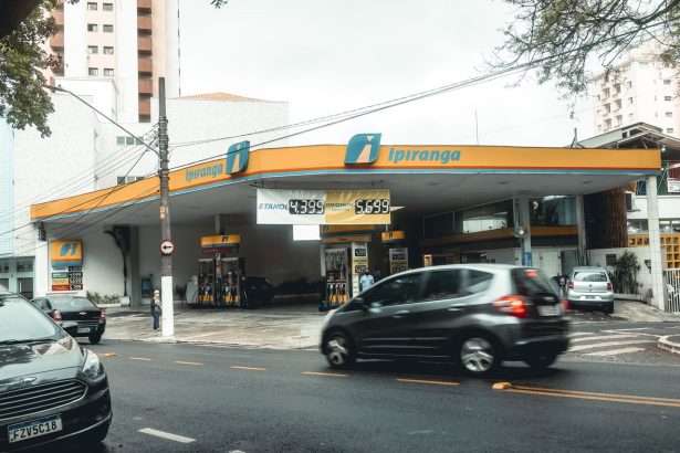 Posto Ipiranga movimentado, com veículos passando e abastecendo em uma área urbana.