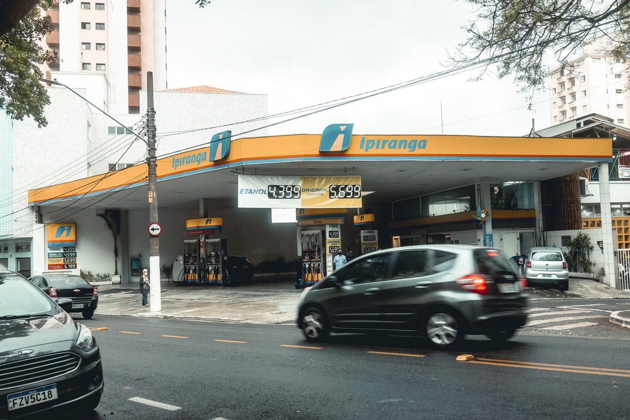 Posto Ipiranga movimentado, com veículos passando e abastecendo em uma área urbana.