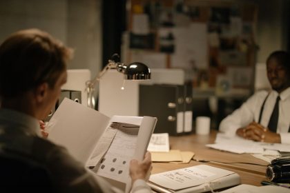 Investigadores analisam documentos em um escritório durante uma apuração.